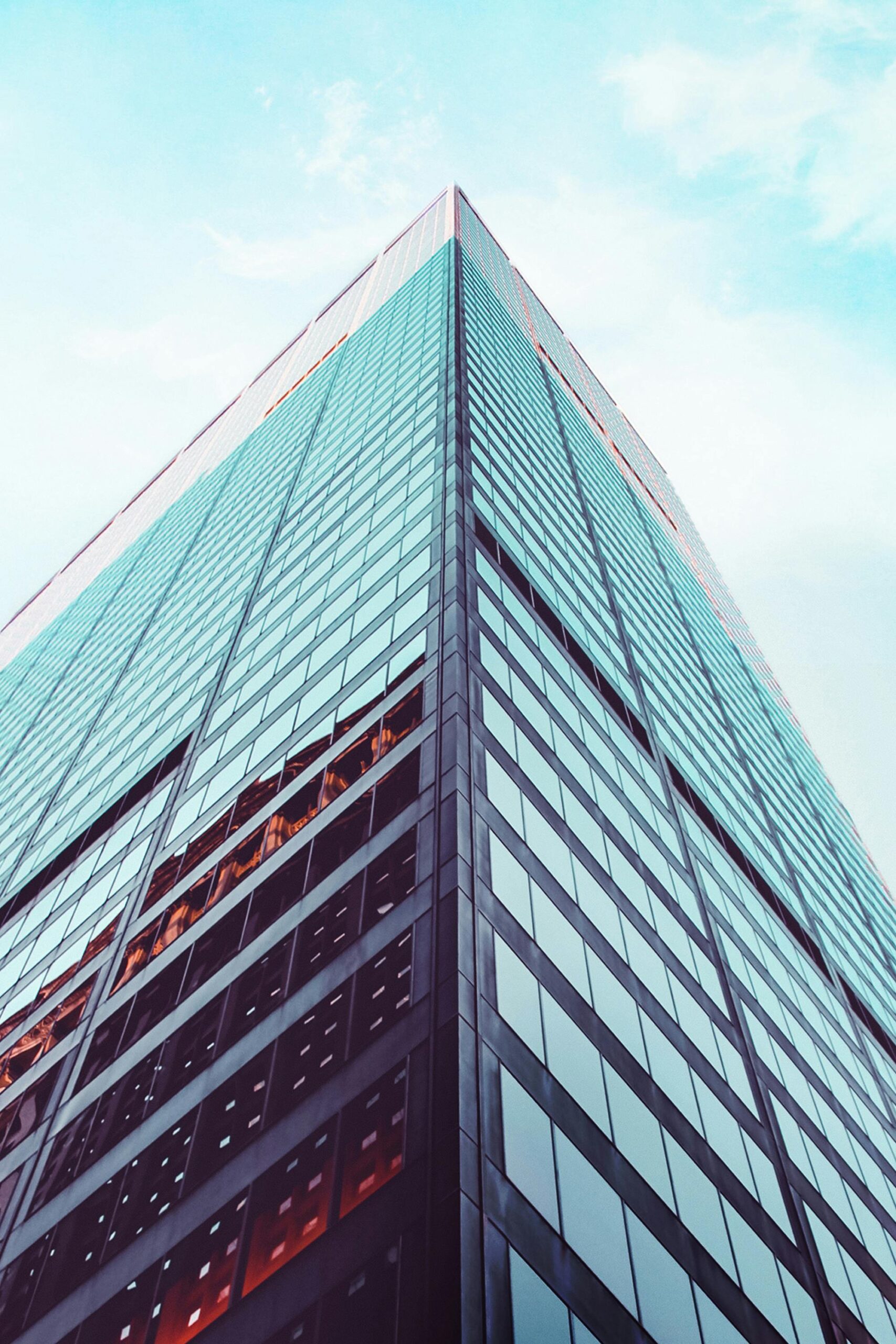 Low angle view of a modern skyscraper in New York City showcasing architectural design against a clear sky.
